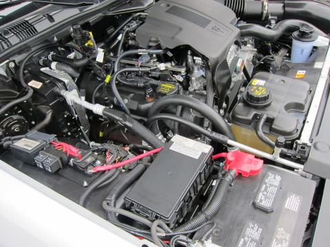 1991 Ford LTD Crown Victoria - Close-up of a clean engine bay showing the V8 engine, battery with red terminal cover, fuse box, and surrounding hoses.