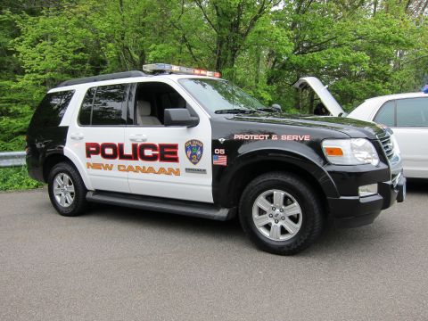 1991 Ford LTD Crown Victoria - black-and-white Ford Explorer SUV lettered POLICE NEW CANAAN with roof lightbar and Protect & Serve markings.