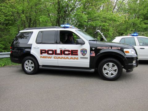 1991 Ford LTD Crown Victoria - Side view of a black-and-white Ford Explorer police SUV lettered POLICE NEW CANAAN with roof lightbar.