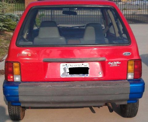 1991 Ford Festiva - Rear view of a red 1991 Ford Festiva, showing its distinctive taillights and bumper.