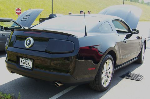 2007 Ford Mustang - Rear view of a black Ford Mustang coupe at a car meet, with another car's hood open in the background.