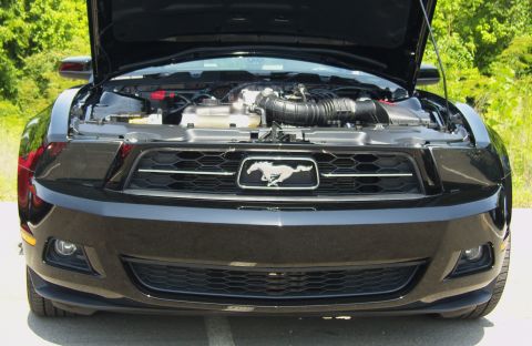 2007 Ford Mustang - The front of a black Ford Mustang is shown with its hood open, revealing the engine compartment.