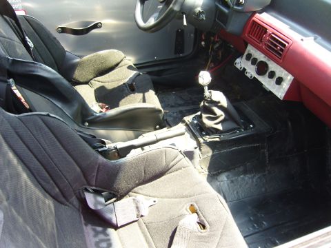 2007 Ford Mustang - The interior of a modified car shows racing seats and a manual transmission shifter.