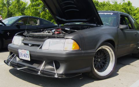 2007 Ford Mustang - Matte black 1987 Ford Mustang with hood open, its engine and custom front splitter.