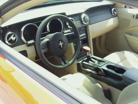 2007 Ford Mustang - The interior of a 2007 Ford Mustang features a tan interior with a black steering wheel and dashboard accents.