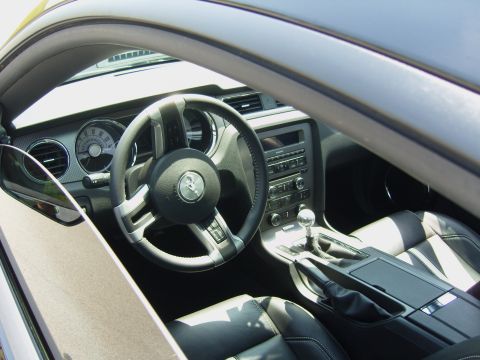 2007 Ford Mustang - The interior of a modern Ford Mustang shows black leather seats and a dashboard with a prominent steering wheel.