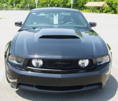 2007 Ford Mustang - Front view of a black Ford Mustang, showing its distinctive grille and hood scoop.