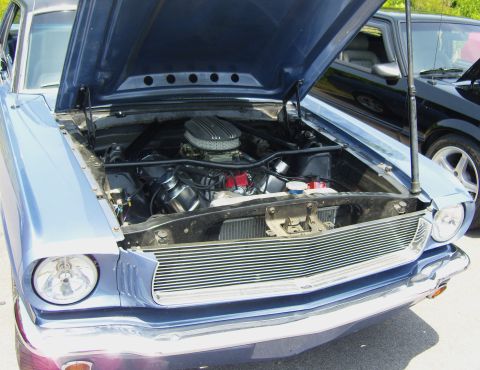 2007 Ford Mustang - A blue classic car with its hood open, revealing the engine, parked next to another vehicle.