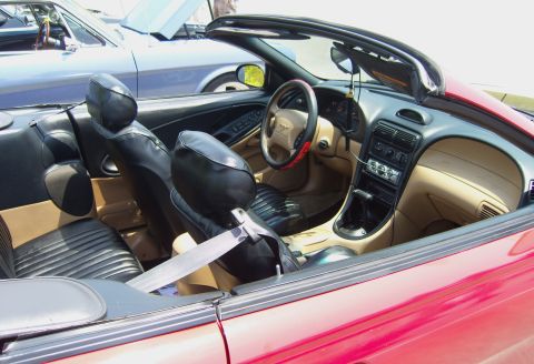 2007 Ford Mustang - Interior view of a red convertible, with another vehicle in the background.