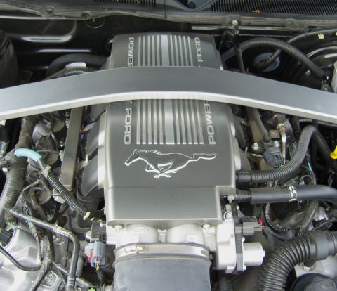 2007 Ford Mustang - Close-up view of a Ford Mustang engine, showing the "POWER" and "FORD" branding along with the iconic running horse emblem.