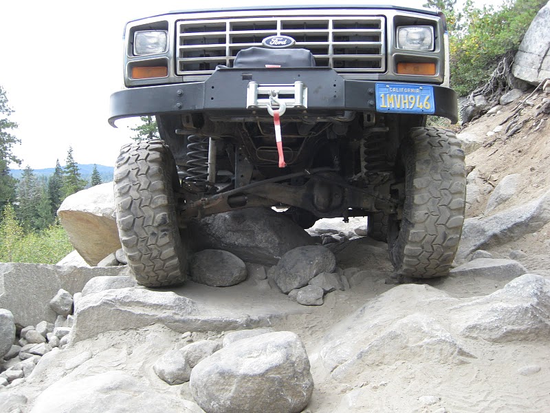 Front view of a Ford Bronco on rocks, showing grille and winch