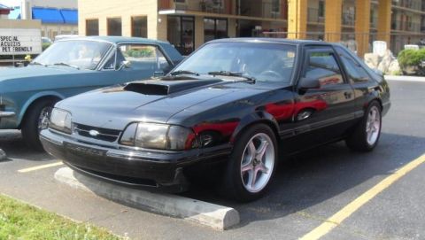 2007 Ford Mustang - A black 1993 Ford Mustang is parked next to a blue car.