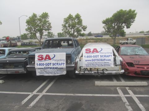 1978 Ford Bronco - Junkyard scene with multiple vehicles, some displaying recycling company banners.