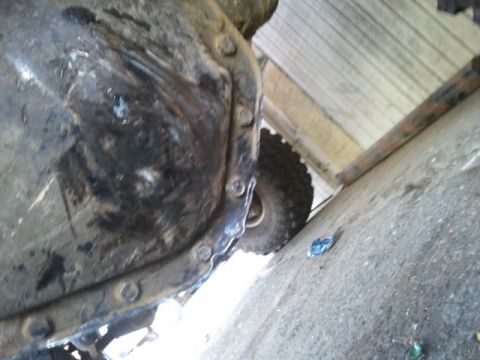 1978 Ford Bronco - Underside view of a vehicle's differential housing and a tire.