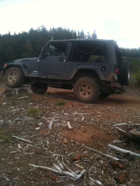 2005 Jeep Wrangler - 2005 Jeep Wrangler parked on uneven terrain with debris on the ground.