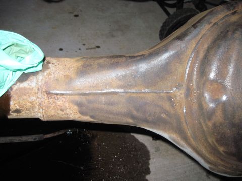 1979 Ford Bronco - Rusty differential housing shown with a gloved hand for scale.