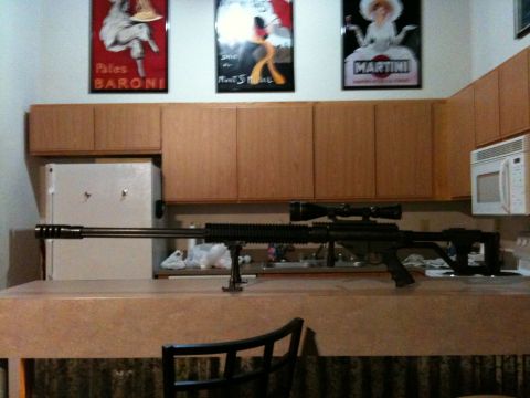 1996 Ford Bronco - A sniper rifle rests on a kitchen counter, with vintage posters and cabinetry visible.