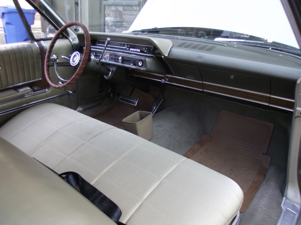 Car interior with beige seats, wood trim, and dashboard. A Supermotors.net watermark is visible