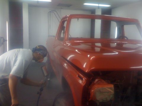 1978 Ford Bronco - A man is spray painting the cab of a 1978 Ford Bronco in a workshop.