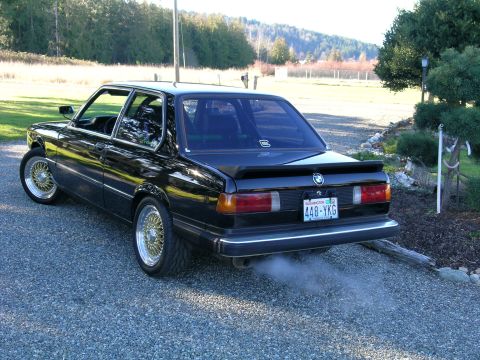 1982 BMW 3 Series - This 1982 BMW 3 Series sedan is captured from the rear, its gold BBS wheels and emitting a plume of smoke from the exhaust.