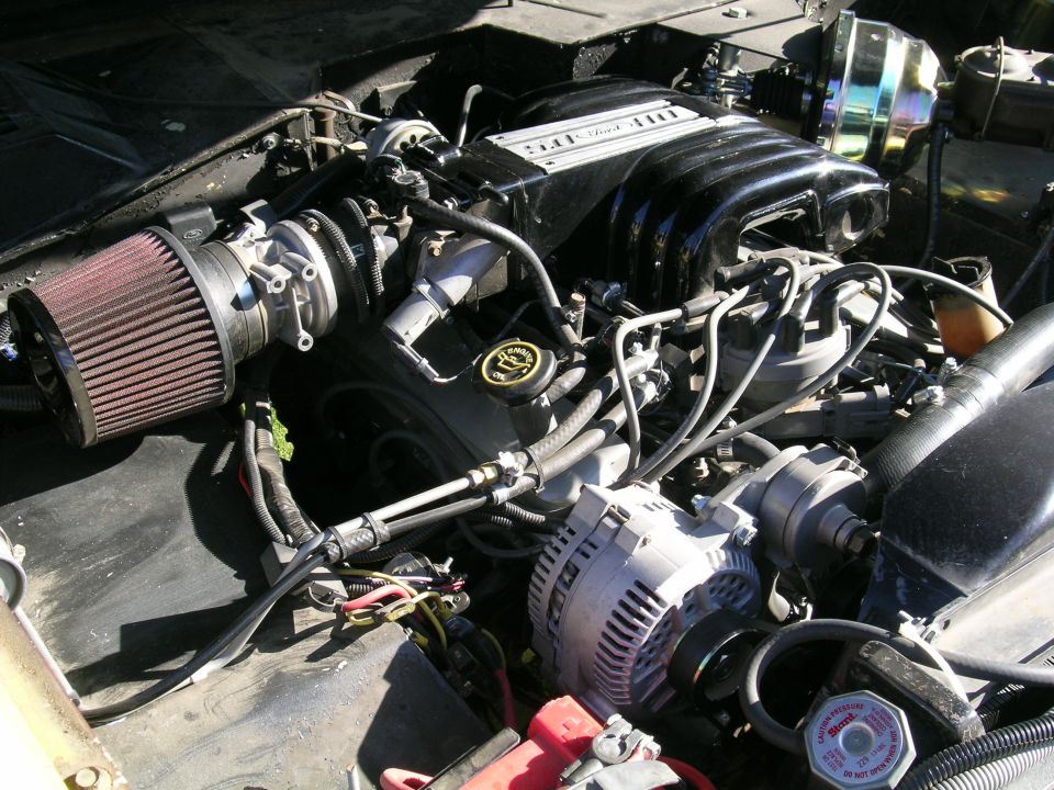 Engine bay with V8 engine, air intake, alternator, and brake booster