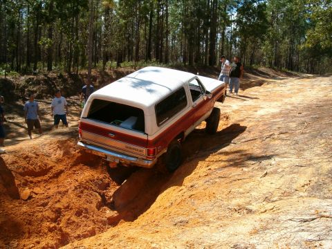 1991 Ford Bronco - This SUV is navigating a challenging off-road terrain with onlookers present.