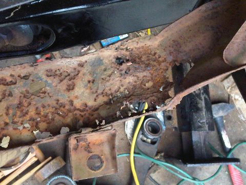 1973 Ford Ranchero - Close-up of a severely corroded vehicle frame rail, showing extensive rust damage and deterioration.