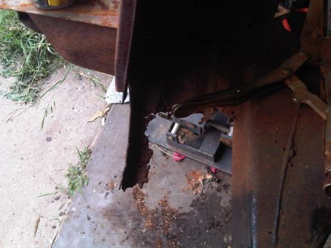 1973 Ford Ranchero - Close-up of heavily rusted metal panel, possibly from a vehicle body, secured with a clamp.