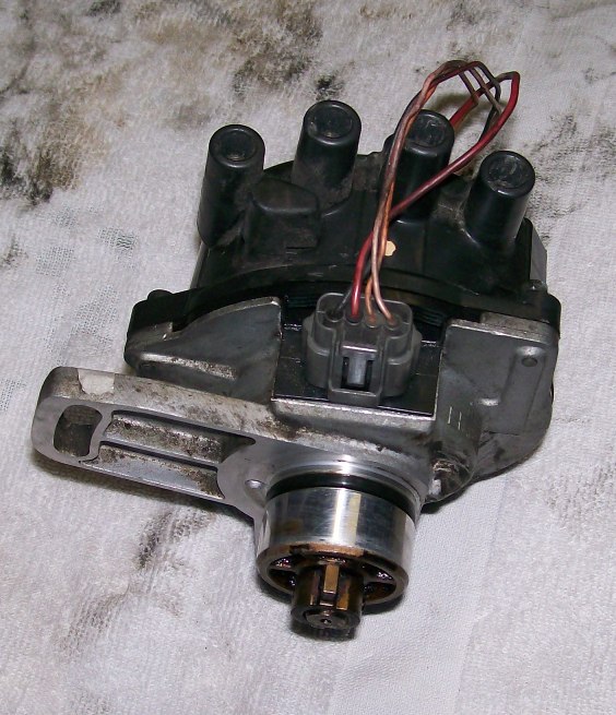 Complete used distributor with aluminum housing, gray connector and black cap on a white shop towel