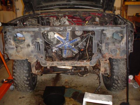 1990 Ford Bronco - The front end of a 1980 Ford Bronco is dismantled, revealing the engine and extensive rust damage.