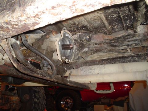 1990 Ford Bronco - Transmission output shaft and chassis detail, with a red fuel tank visible.