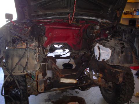 1990 Ford Bronco - The engine bay of a vehicle is shown with the hood up, revealing the internal components and wiring harness.