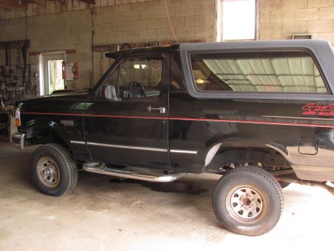 1995 Ford Bronco - This black 1995 Ford Bronco features red pinstripes and a 4x4 off-road decal on the rear quarter panel.