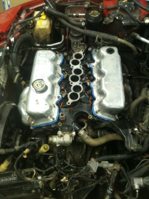 1990 Ford Probe - Engine bay with intake manifold removed, exposing valve covers and internal engine components.