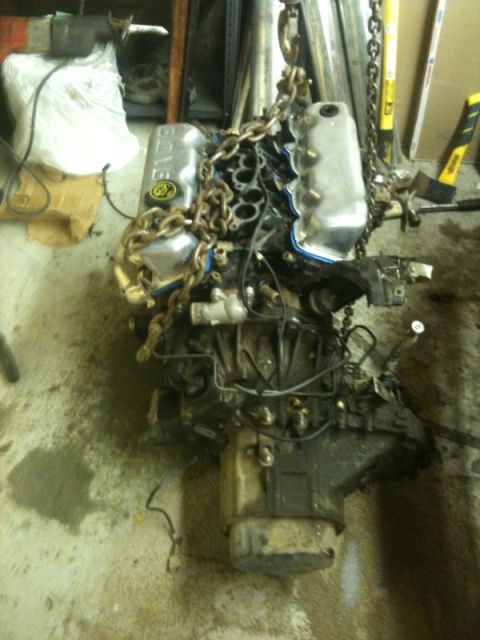 1990 Ford Probe - Engine assembly is being hoisted, with "SUPERMOTORS" branding visible on the floor.