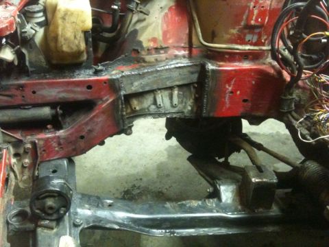1990 Ford Probe - Close-up view of the engine bay structure, showing red paint, exposed metal, and wiring harnesses.