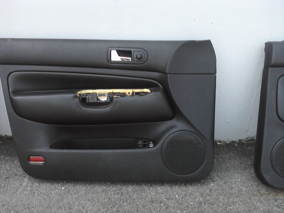 Black car door panel with speaker and window controls