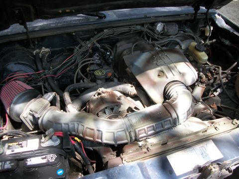 1994 Ford Explorer - Close-up view of a vehicle's engine compartment, showing various hoses, wires, and the air intake system.