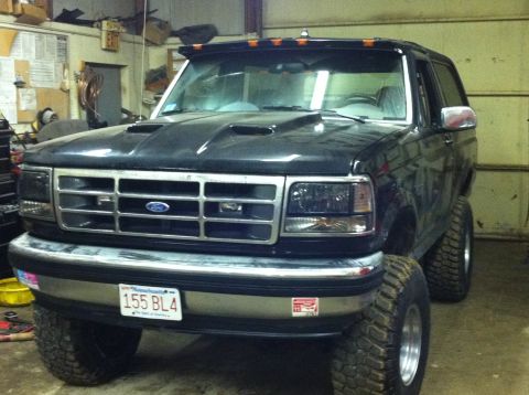 1993 Ford Bronco - This lifted Ford Bronco, likely a 1992 model, is shown from the front-three-quarter view in a garage setting.