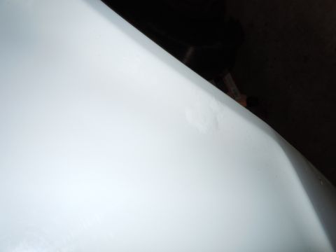 2001 Ford Crown Victoria - White car fender detail, showing minor surface imperfections.
