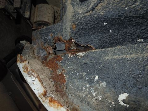 2001 Ford Crown Victoria - Close-up view of significant rust and corrosion on a vehicle's undercarriage structure.