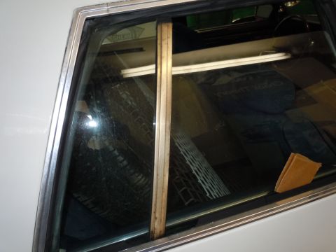 2001 Ford Crown Victoria - The interior of a white vehicle is visible, with a wooden trim piece and a reflection of a sheriff's badge on the window.