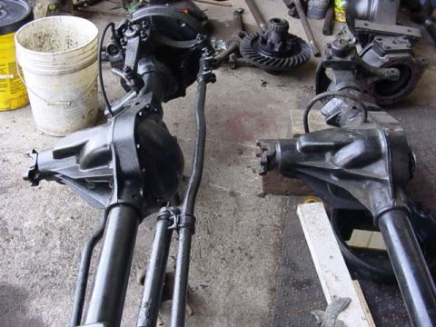 1992 Ford Bronco - Differential axles and steering components are laid out on a concrete surface.