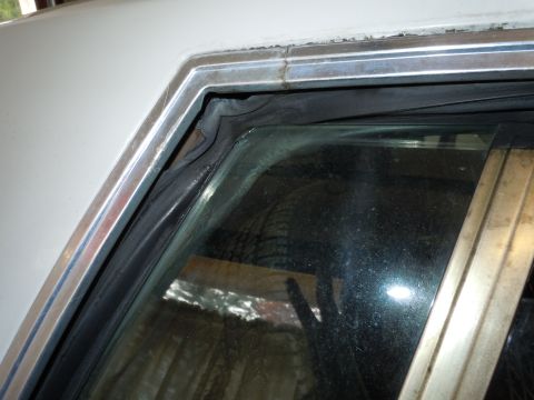 2001 Ford Crown Victoria - Detail of a car's window seal and trim, likely showing wear or damage.