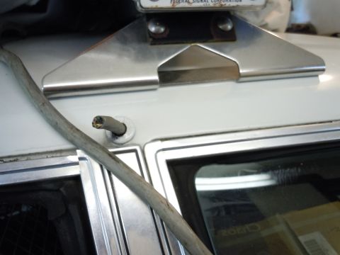 2001 Ford Crown Victoria - A metal mount, possibly for a police light, is attached to the roof of a white vehicle.
