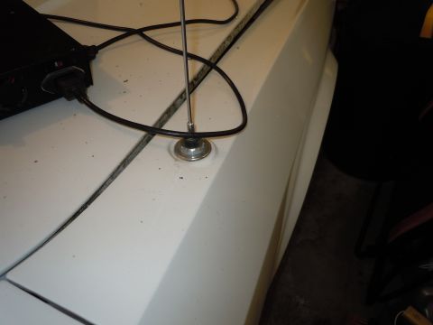 2001 Ford Crown Victoria - Close-up of a car's fender showing an antenna mount and a power cord.