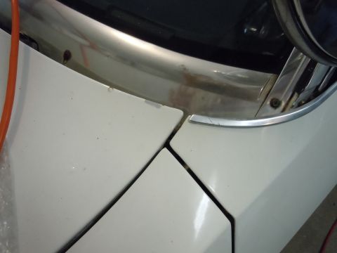 2001 Ford Crown Victoria - Close-up of the hood and fender seam on a white 2001 Ford Crown Victoria, showing the chrome trim detail.