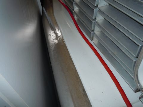 2001 Ford Crown Victoria - A close-up interior shot reveals a red cable running alongside stacked metal components within a vehicle.