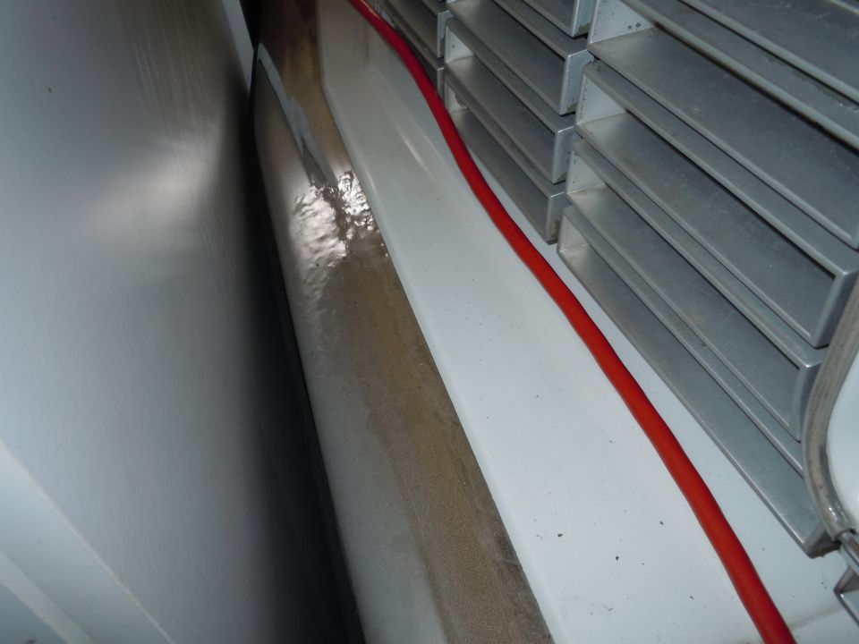 Interior view of a vehicle showing a red cable and stacked metal components