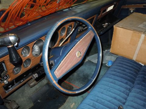 2001 Ford Crown Victoria - The interior of a car shows blue velour seats and a dashboard with wood-grain accents.